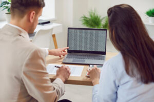 Business people working with laptop at office desk, doing accounting analysis on computer platform, analyzing cloud data statistics, busy with online trade market tech research, intern learning, rear