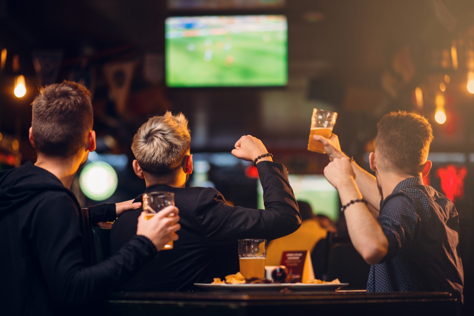 Men at a bar watching football