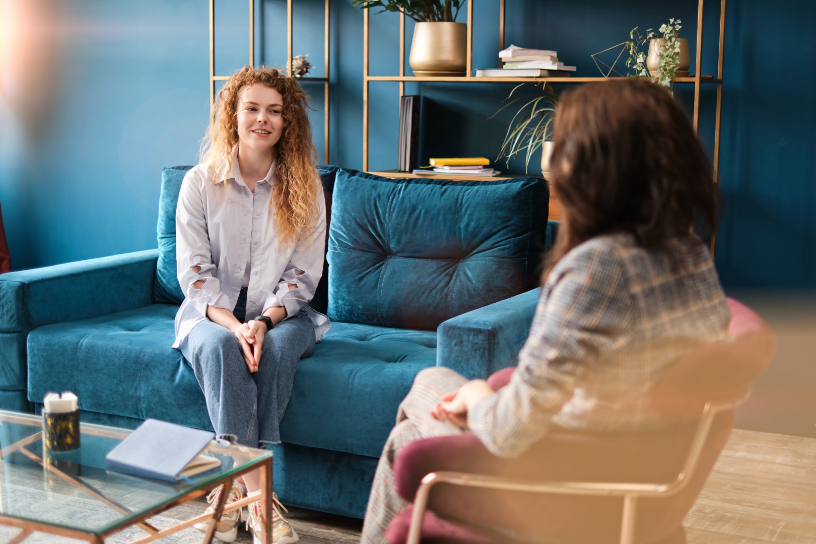 Happy red-haired woman talking to a female psychologist