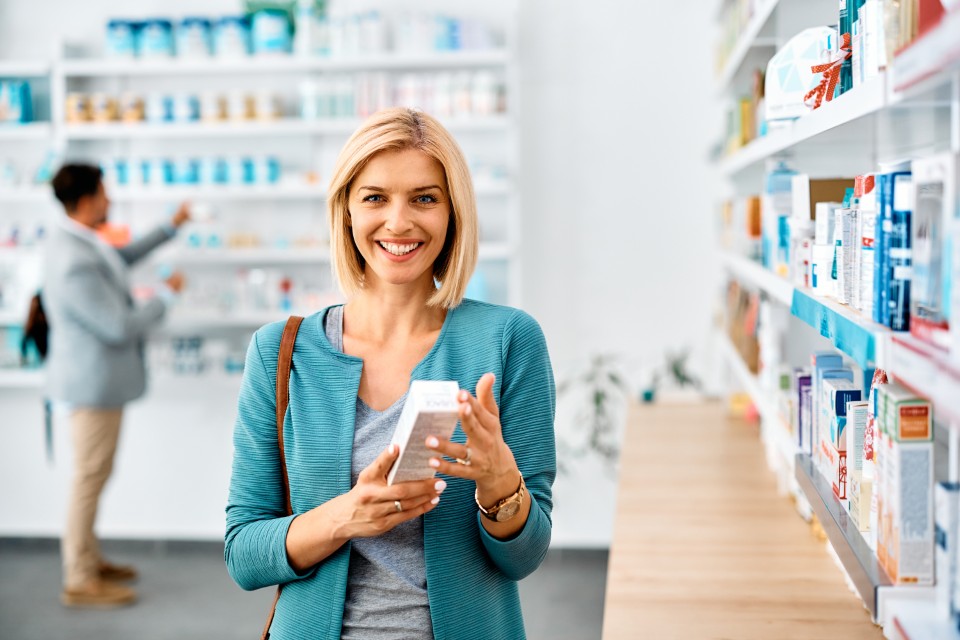 Happy woman buying in pharmacy